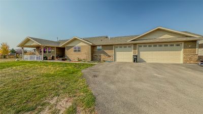 Ranch-style home with a front yard and a garage | Image 1