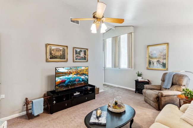 Vaulted ceilings enhance the spacious feel of the living area in this well-maintained home, lovingly cared for by its original owner. | Image 5