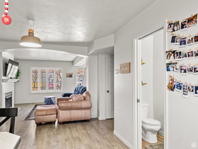 Living room with a textured ceiling and light wood-type flooring | Image 10