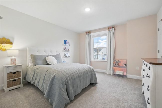 Charming and spacious bedroom with soft neutral tones, plush carpeting, and a large window that fills the room with natural light. Clean lines and a calming palette make it a perfect retreat for rest and relaxation. 2 Closets! | Image 25