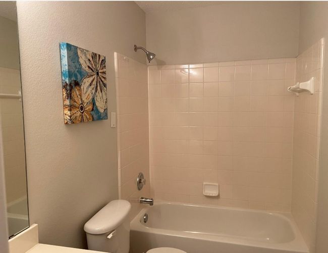 Full bath featuring tub / shower combination, a textured wall, vanity, and a textured ceiling | Image 15