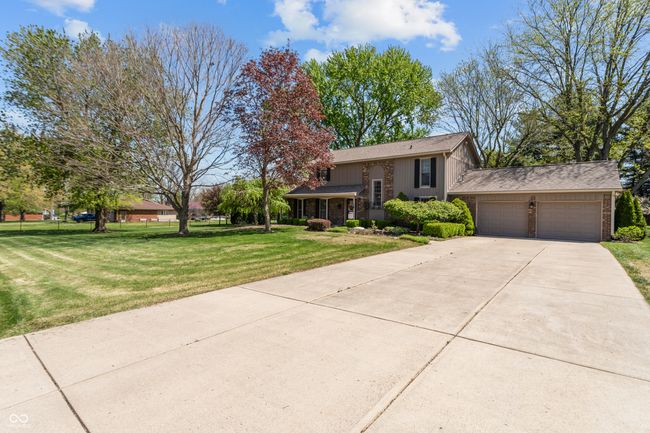 split foyer home with concrete driveway, brick siding, a front yard, and a garage | Image 46