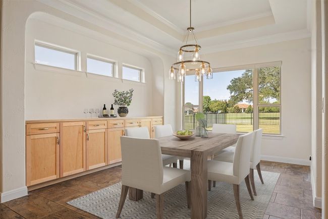 Virtually staged. Huge dining space featuring healthy amount of natural light, a tray ceiling, ornamental molding, and a chandelier | Image 5
