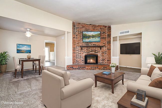 Carpeted living area with lofted ceiling, a fireplace, and ceiling fan | Image 6