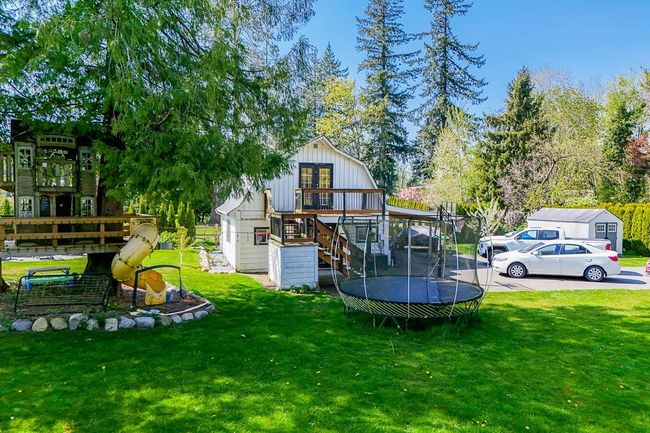 Exterior space with a yard, stairs, a wooden deck, and a trampoline | Image 31