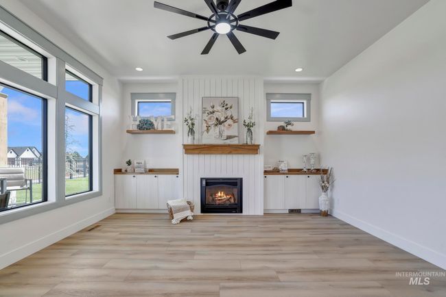 Unfurnished living room featuring a large fireplace, recessed lighting, light wood finished floors, and ceiling fan | Image 7