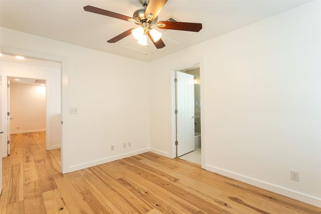 Empty room with light wood finished floors and a ceiling fan | Image 17