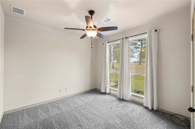 Carpeted spare room featuring ceiling fan, visible vents, and baseboards | Image 16