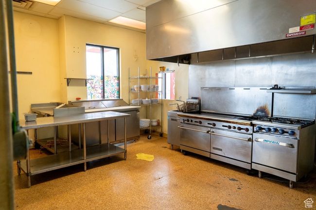 Kitchen with range with two ovens, a drop ceiling, exhaust hood, and visible vents | Image 27