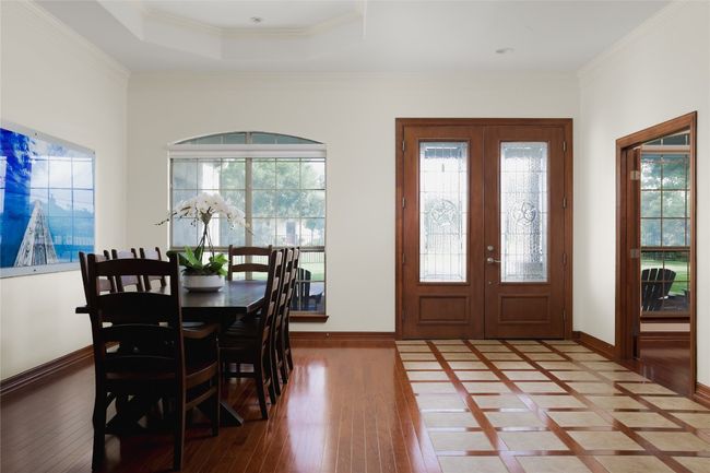 Foyer featuring wood-type flooring, baseboards, healthy amount of natural light, ornamental molding, and french doors | Image 13