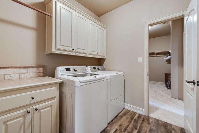The laundry room features built in storage as well as access from both the hallway AND the primary closet. | Image 21
