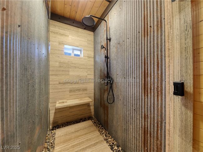 Full bath with wooden walls, wooden ceiling, and tiled shower | Image 21