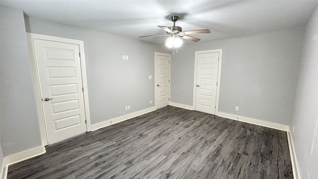 Unfurnished bedroom featuring dark wood finished floors, a closet, and a ceiling fan | Image 11