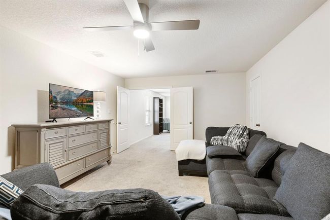Enjoy movie nights and game days in this spacious media room, located upstairs right off the flex space, also featuring a storage closet. | Image 32