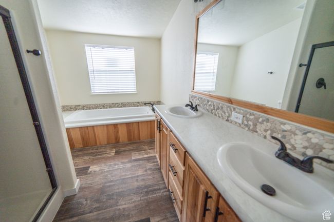 Full bathroom with wood finished floors, a sink, and a stall shower | Image 13