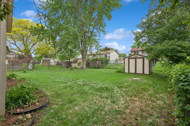 The backyard is relatively flat and features an included shed for your storage needs. | Image 24