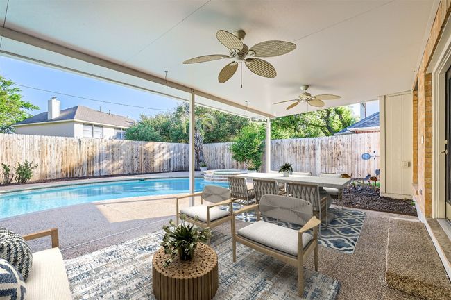 View of pool featuring a fenced backyard, a ceiling fan, a patio area, a pool with connected hot tub, and outdoor dining area | Image 37