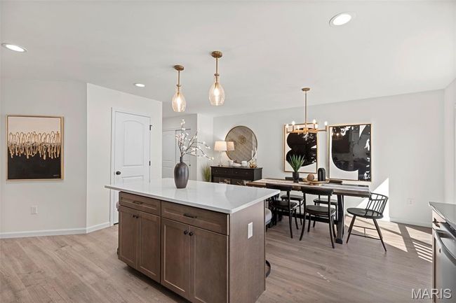 Kitchen with light wood-type flooring, recessed lighting, baseboards, light countertops, and hanging light fixtures | Image 11