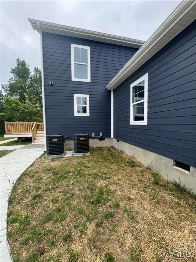 View of property exterior with cooling unit, a yard, and a wooden deck | Image 39