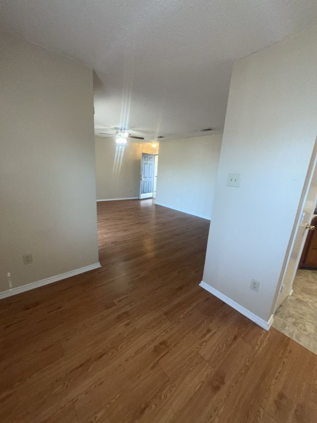 Unfurnished room with baseboards, wood finished floors, and ceiling fan | Image 13