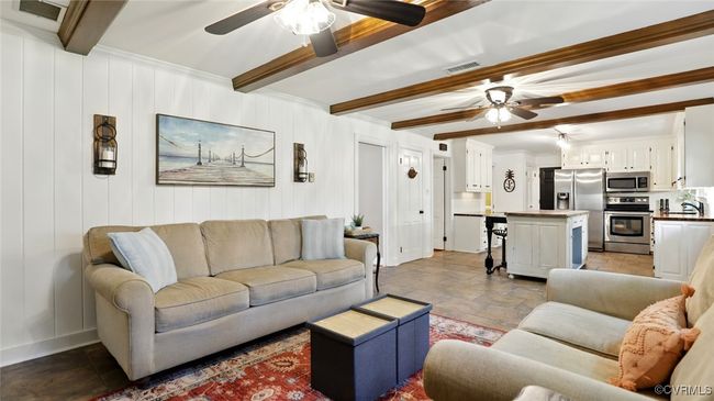 Living room with a ceiling fan, beam ceiling, and stone tile floors | Image 31