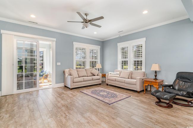 Living area with a ceiling fan, wood finished floors, baseboards, visible vents, and recessed lighting | Image 10