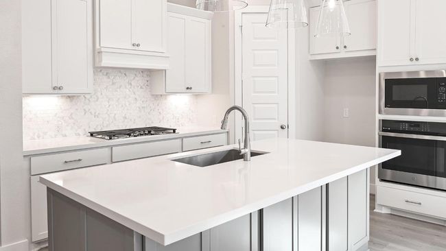 Kitchen with stainless steel appliances, tasteful backsplash, a kitchen island with sink, hanging light fixtures, and white cabinetry | Image 8