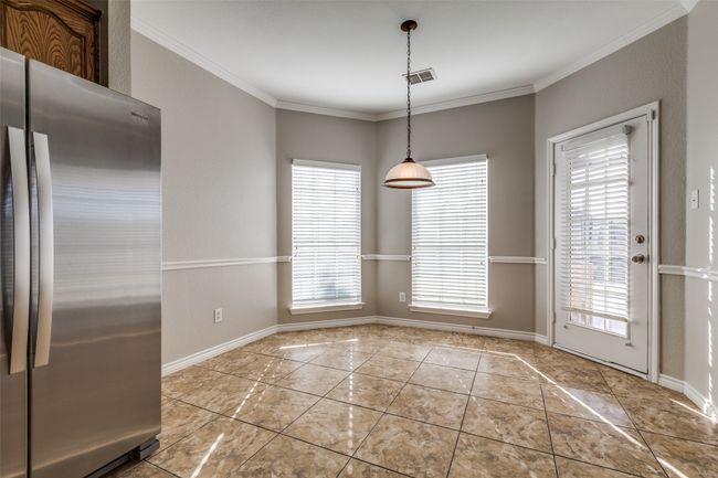 Unfurnished dining area featuring ornamental molding, visible vents, and plenty of natural light | Image 11