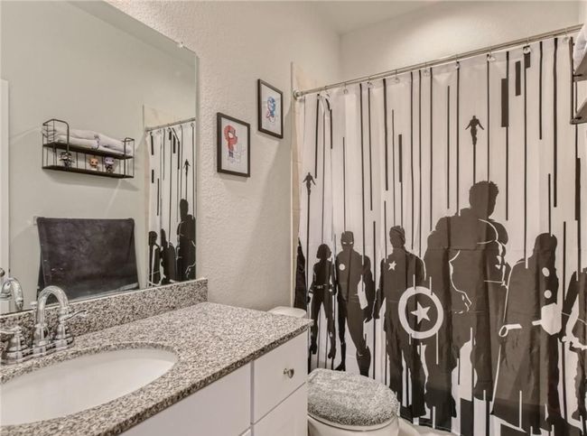 Full bath featuring a textured wall, vanity, and a shower with curtain | Image 7