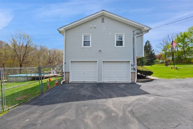 View of home's exterior featuring fence, a yard, an attached garage, and aphalt driveway | Image 37