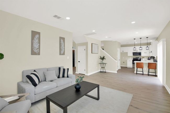 Living room with light wood-type flooring, visible vents, and stairs | Image 8