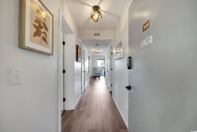 Corridor with wood-type flooring and crown molding | Image 3