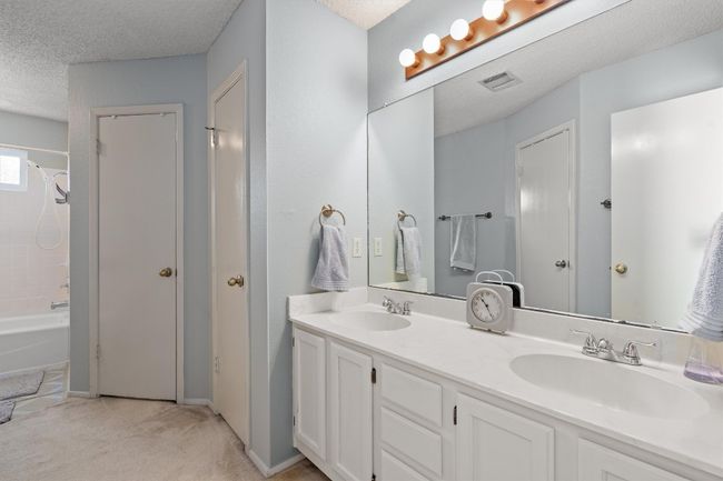The primary bathroom features dual vanities and two walk-in closets. | Image 21