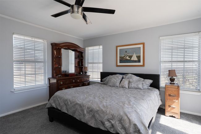 Bedroom featuring carpet flooring, baseboards, crown molding, and ceiling fan | Image 16