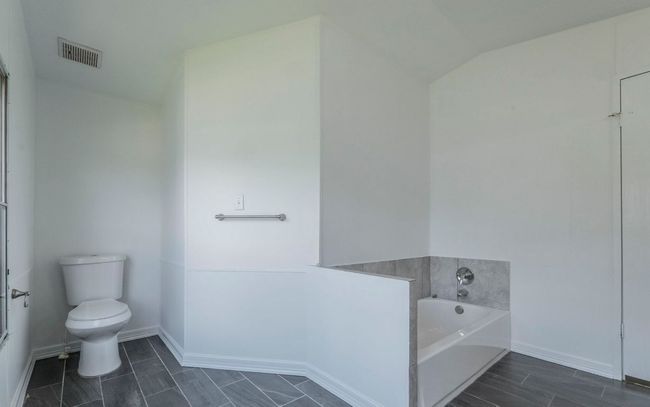Bathroom featuring a bath and lofted ceiling | Image 10