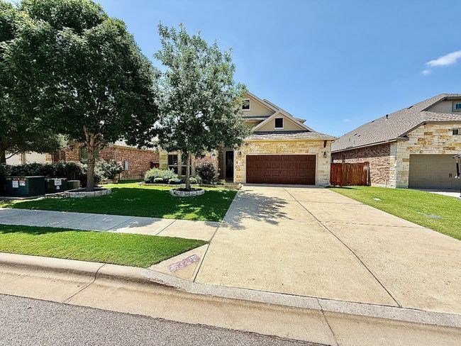 View of front facade with an attached garage, stone siding, and driveway | Image 40
