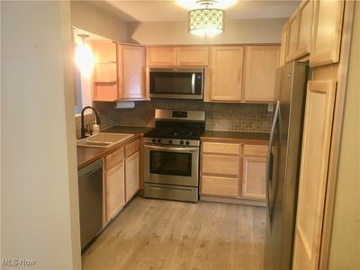 Kitchen with light brown cabinets, stainless steel appliances, and sink | Image 2