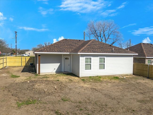 Rear view of house with a fenced backyard and roof with shingles | Image 28