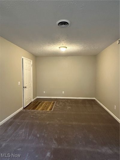 Carpeted empty room with a textured ceiling | Image 3