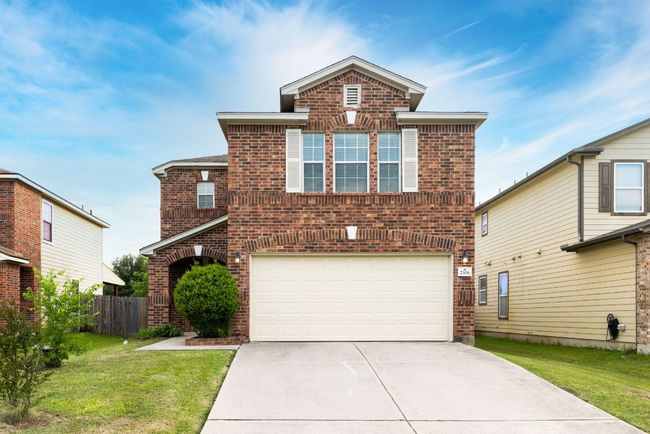 Traditional-style house featuring brick siding, an attached garage, and concrete driveway | Image 4