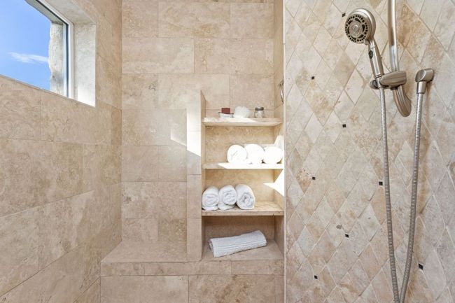 The spacious walk-in shower features sleek tilework and a retractable shower head, offering both luxury and ease of use. | Image 17