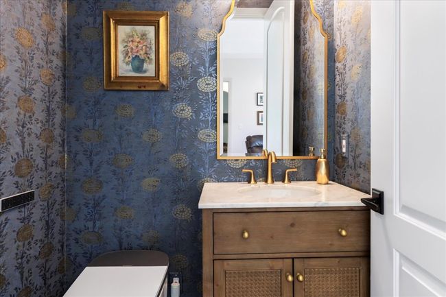 Bathroom with vanity, wallpapered walls, and toilet | Image 24