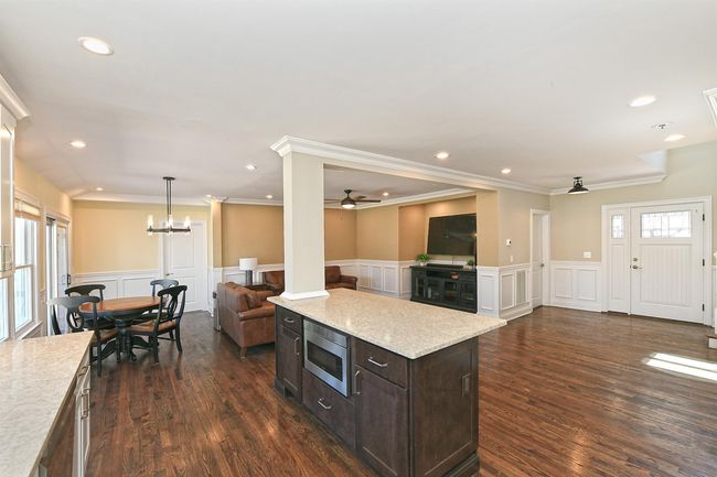 Kitchen with stainless steel microwave, a decorative wall, open floor plan, and a wainscoted wall | Image 18