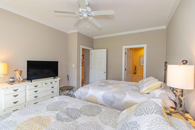 Bedroom featuring ensuite bath, ornamental molding, and ceiling fan | Image 24