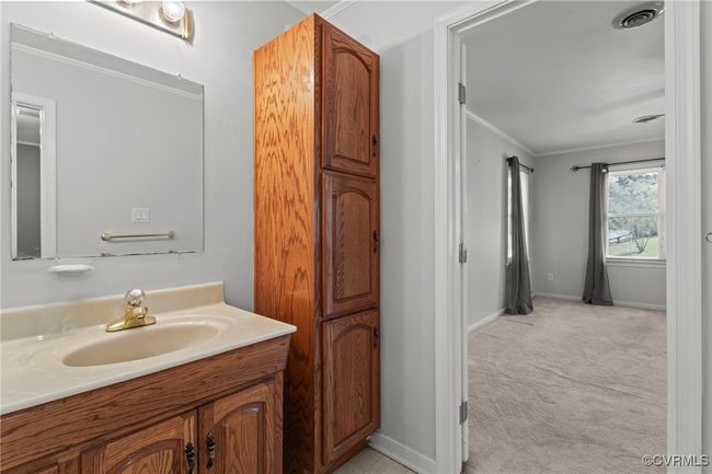 Bathroom featuring visible vents, vanity, baseboards, and ornamental molding | Image 24