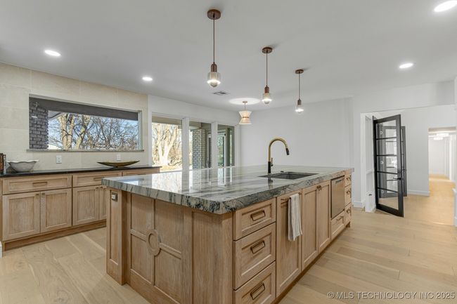 Main kitchen with luxury counters, luxury appliances, bar seating, and custom cabinets | Image 21