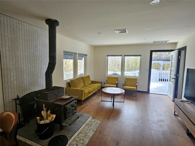 Living room with a wood stove, hardwood / wood-style flooring, recessed lighting, and baseboards | Image 10