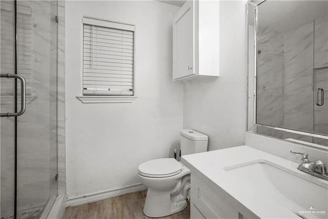 Bathroom featuring vanity, a shower stall, and wood finished floors | Image 6
