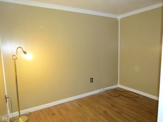 spare room with light wood-type flooring, baseboards, and crown molding | Image 10
