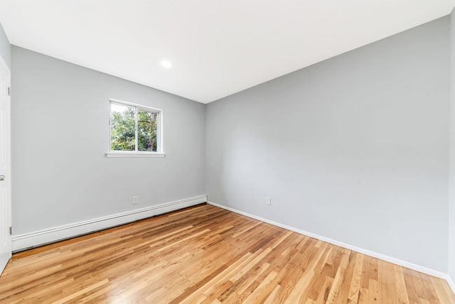 Empty room featuring baseboards, light wood-style floors, and a baseboard radiator | Image 13